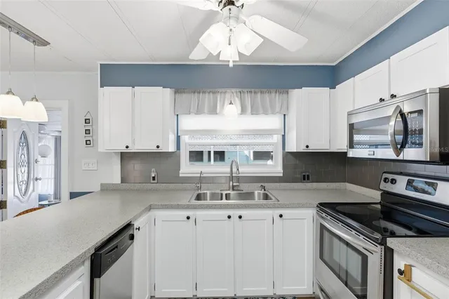 a kitchen with stainless steel appliances granite countertop a dining table chairs a sink and dishwasher a refrigerator with wooden floor