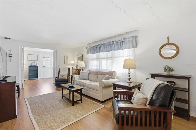 a living room with furniture wooden floor and a flat screen tv