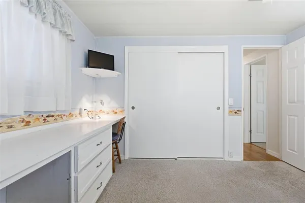 a bedroom with a bed a chandelier and a mirror