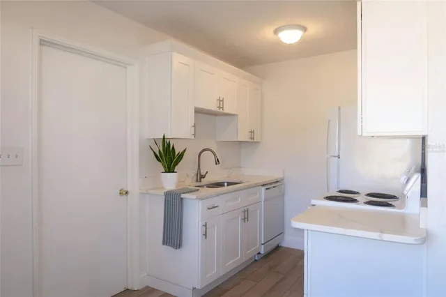 a kitchen with a sink a stove and cabinets