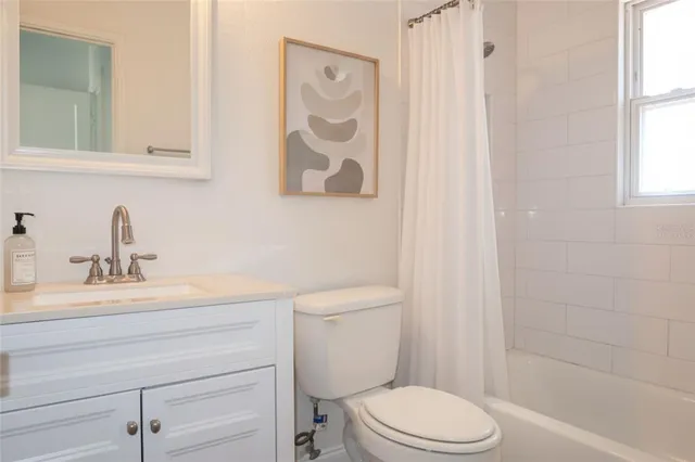 a bathroom with a toilet sink vanity and mirror