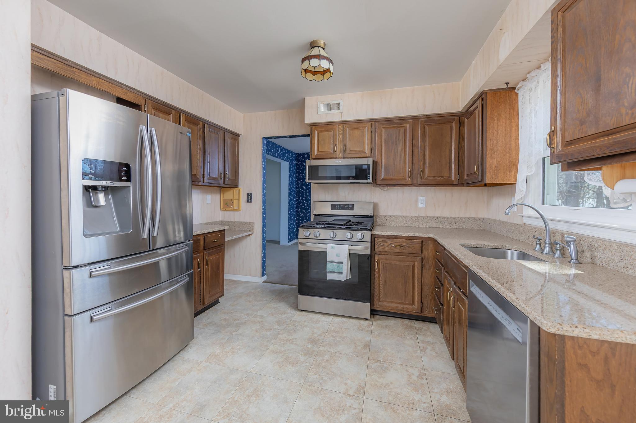 17 Framingham Road Beverly, NJ 08010 - Photo 3 of 24 a kitchen with a refrigerator sink and wooden cabinets