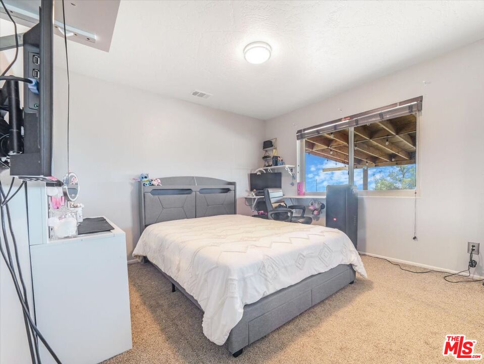 9446 Green Road Pinon Hills, CA 92372 - Photo 21 of 24 a bedroom with a bed and a window