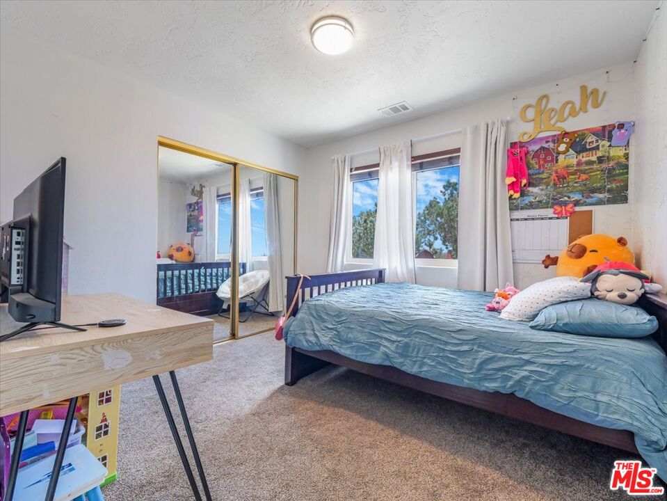 9446 Green Road Pinon Hills, CA 92372 - Photo 22 of 24 a bedroom with bed and glass door