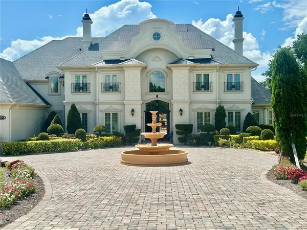 a front view of a house with a yard and potted plants