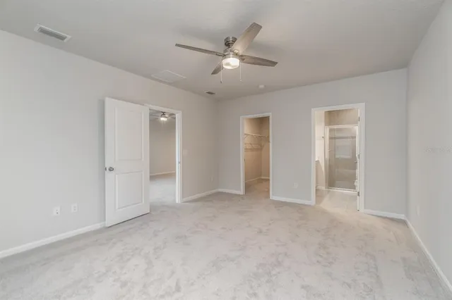 a view of an empty room with a ceiling fan