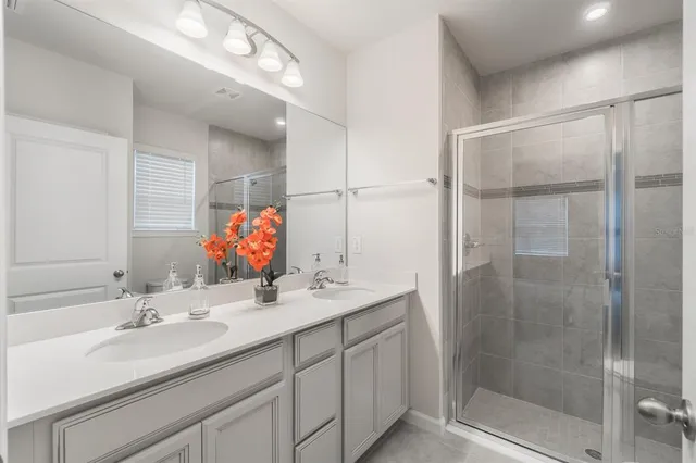 a bathroom with a sink shower and a mirror
