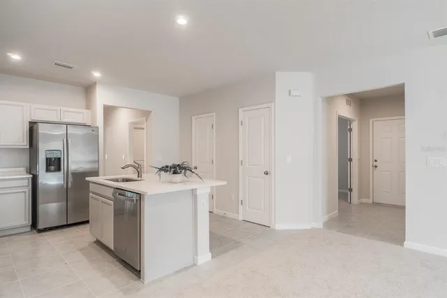a kitchen with stainless steel appliances granite countertop a refrigerator and a sink