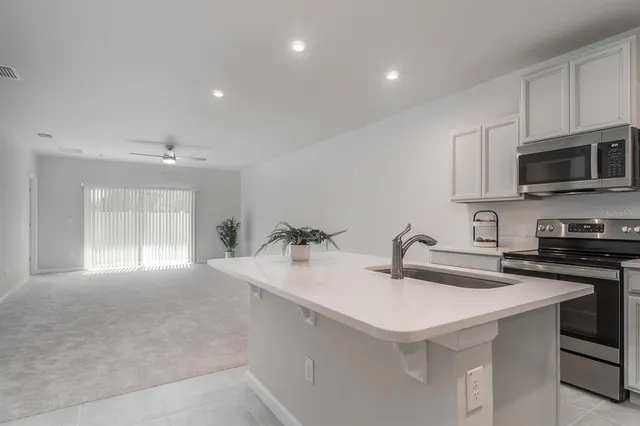 a kitchen with sink a microwave and cabinets