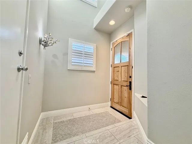 a view of an empty room with cabinet and a window