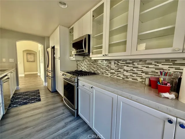 a kitchen with stainless steel appliances a refrigerator a sink and wooden cabinets