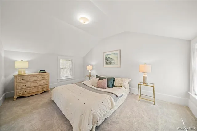 a bedroom with a bed and a lamp on dresser