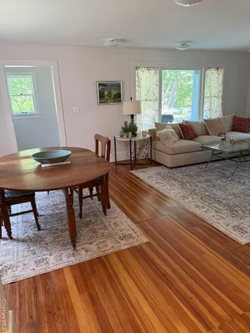 a living room with furniture a large window and a wooden floor