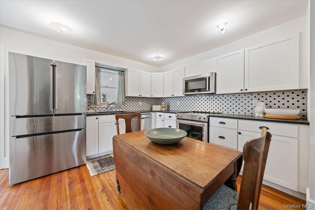 2585 River Road Damascus, PA 18415 - Photo 7 of 41 a kitchen with granite countertop a refrigerator a stove a sink dishwasher a dining table and chairs with wooden floor
