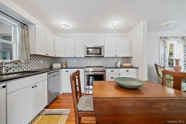 a kitchen with sink a stove and chairs