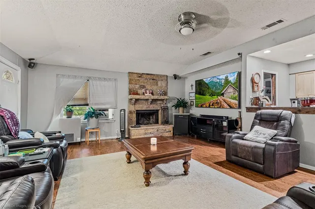 a living room with furniture a flat screen tv and a refrigerator