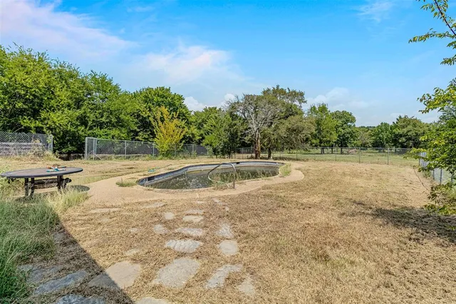 a view of a white house with a swimming pool and a yard