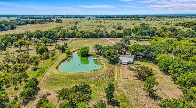 a view of a swimming pool with lawn chairs under an umbrella