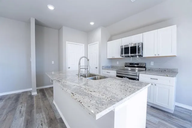 a kitchen with sink a microwave and cabinets