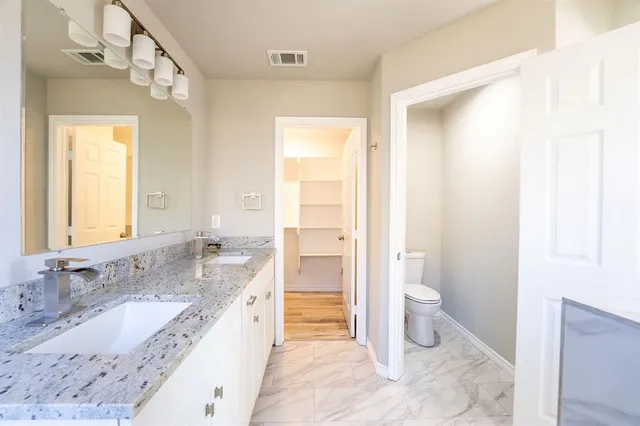 a bathroom with a granite countertop sink toilet and shower