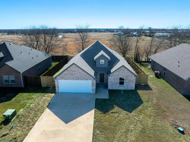 an aerial view of a house with a garden and lake view