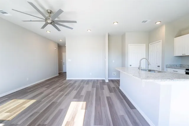 a view of a kitchen with sink and dishwasher with wooden floor