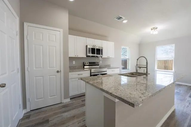 a kitchen with granite countertop a stove and a sink