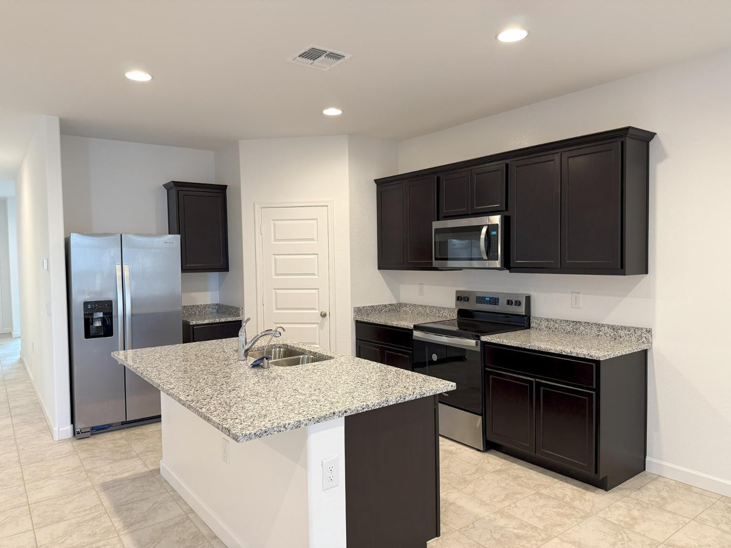 1840 West Spaulding Avenue Apache Junction, AZ 85120 - Photo 13 of 53 a kitchen with stainless steel appliances kitchen island granite countertop a stove refrigerator and microwave