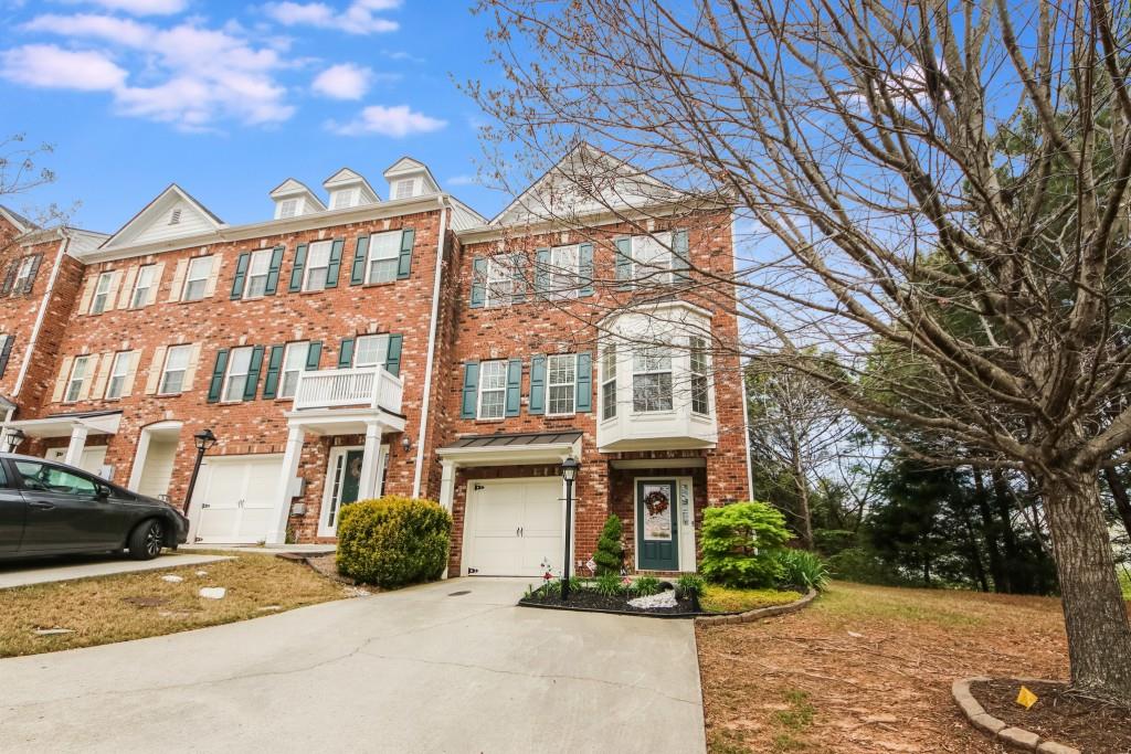 1190 Lake Point Way Suwanee, GA 30024 - Photo 1 of 1 a front view of a residential apartment building with a yard