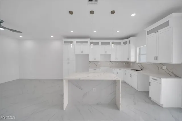 a large white kitchen with a sink and dishwasher