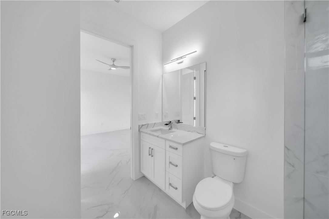1155 Countess Avenue Lehigh Acres, FL 33974 - Photo 24 of 36 a bathroom with a toilet a sink and a mirror
