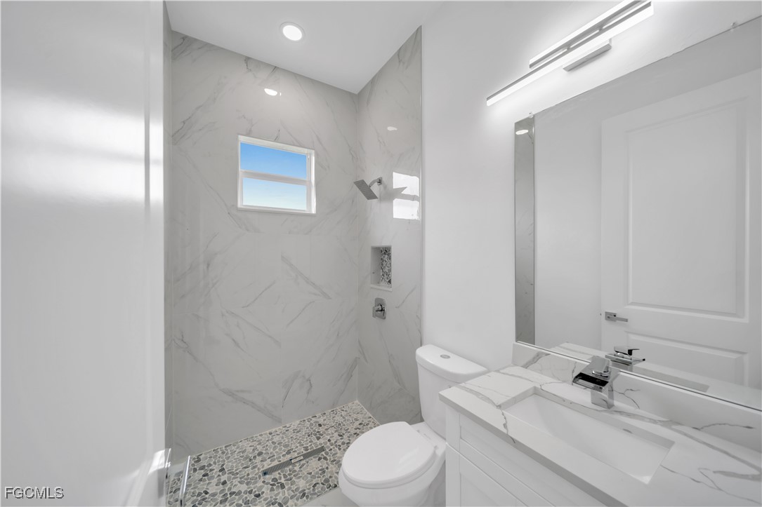 1155 Countess Avenue Lehigh Acres, FL 33974 - Photo 25 of 36 a bathroom with a sink a toilet and shower