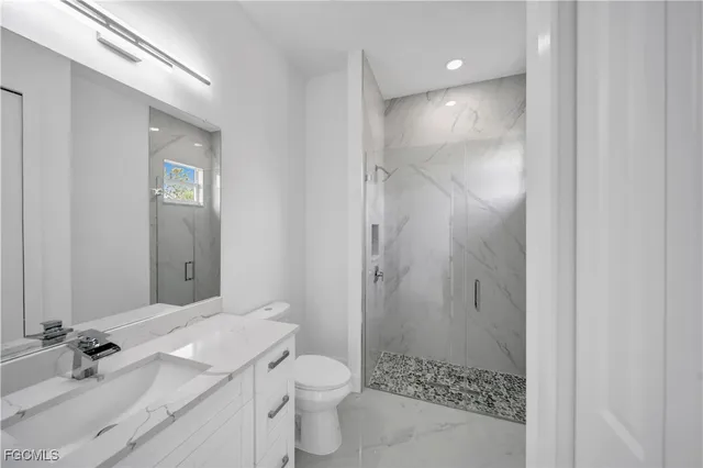 a bathroom with a granite countertop sink toilet and shower