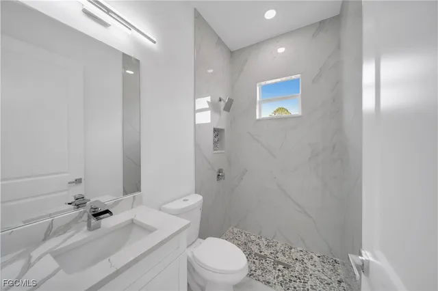 a bathroom with a sink a toilet and shower