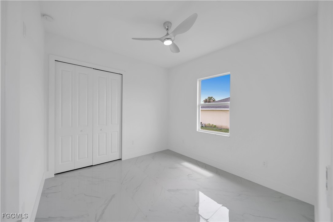 1155 Countess Avenue Lehigh Acres, FL 33974 - Photo 30 of 36 an empty room with a window and a ceiling fan