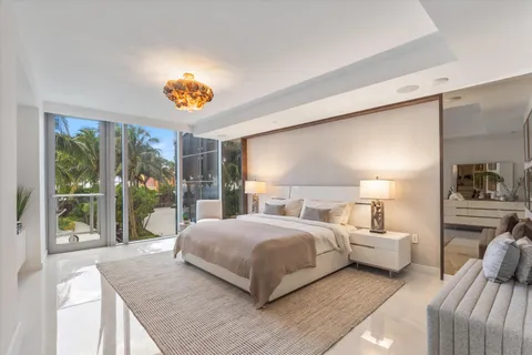 a bedroom with a balcony a large bed and a window