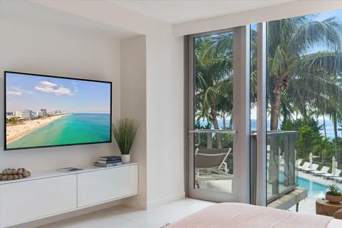 a living room with patio furniture and a large window