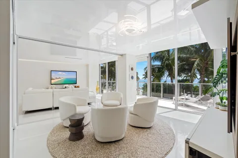 a living room with furniture a window and potted plants