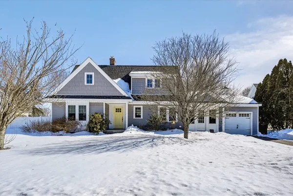 a front view of a house with a yard covered in snow