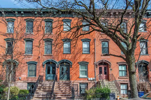 a front view of a residential apartment building with a yard
