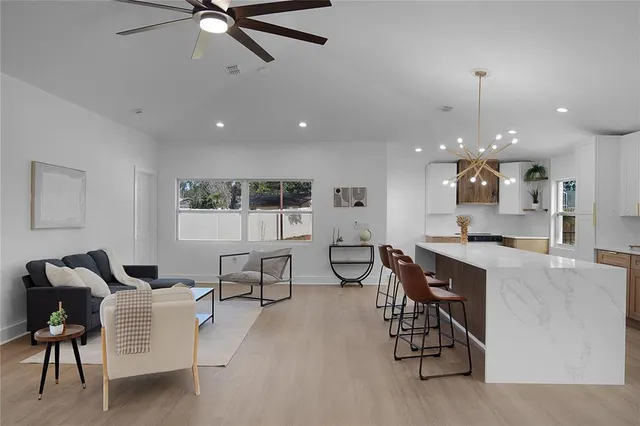 a kitchen with stainless steel appliances granite countertop table chairs sink and cabinets