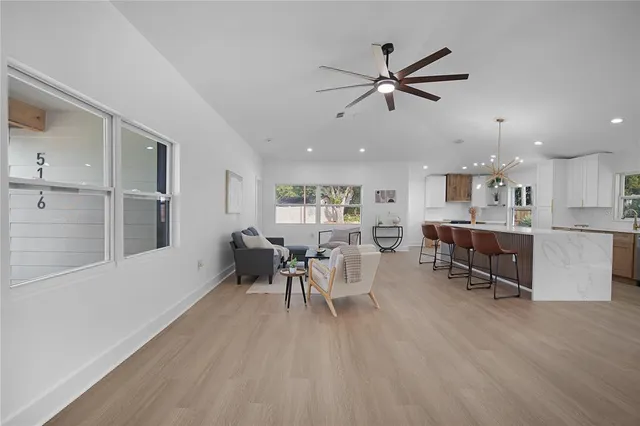 a large kitchen with stainless steel appliances a large counter top a stove a chimney a sink and a large window