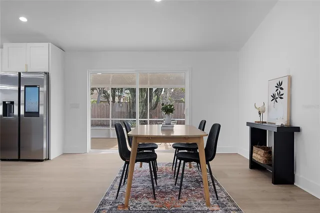 a large white kitchen with a large island oven a stove and a refrigerator with wooden floor