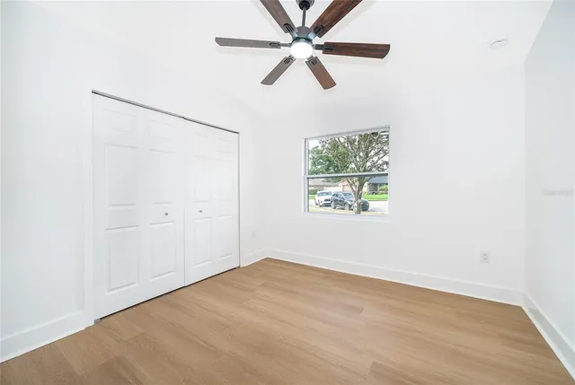 a view of a house with a yard and palm trees