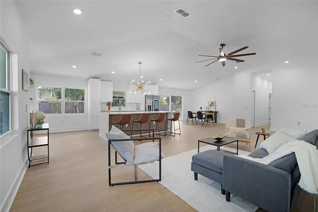 a kitchen with a dining table chairs and sink