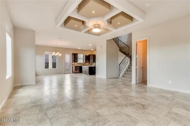 a view of empty room with a kitchen