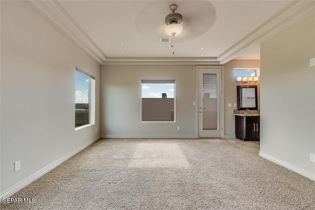 401 Ana Way, Unit B El Paso, TX 79912 - Photo 21 of 28 an empty room with chandelier fan and windows