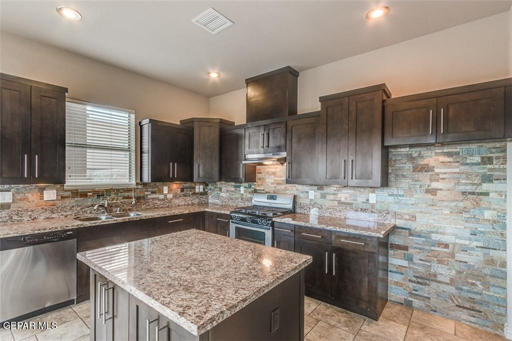 401 Ana Way, Unit B El Paso, TX 79912 - Photo 25 of 28 a kitchen with a stove sink and cabinets