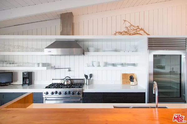 a kitchen with stainless steel appliances kitchen island granite countertop a table chairs in it and wooden floor