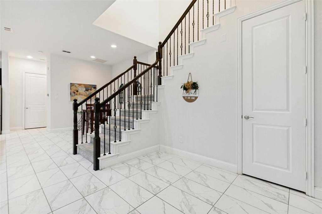 605 Ansley Way Allen, TX 75013 - Photo 8 of 28 Staircase with wrought iron balusters and dark wood handrails